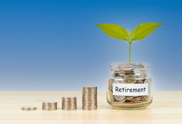 Coin glass jar container and stacks on wooden desk, retirement saving concept (iStockphoto)
