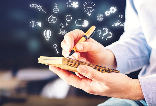 Picture of hand holding notebook - other hand writing