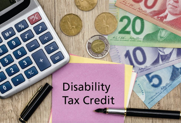 Canadian currency, calculator and notepad with the words "Disability Tax Credit" (iStockphoto)
