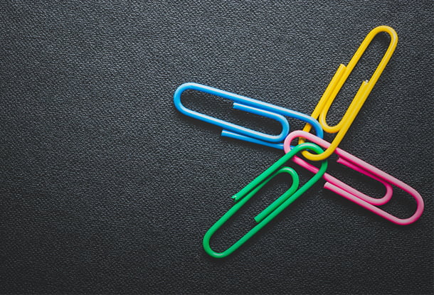 Paper clips on black background, teamwork and success (iStockphoto)
