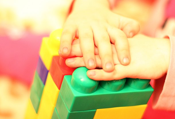 Child's hands on building blocks (iStockphoto)
