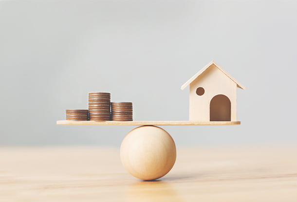 image: Wooden home and money coins stack on wood scale (iStockphoto)
