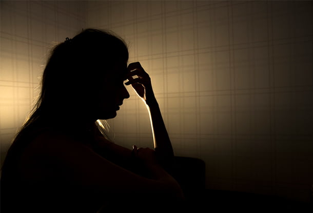photo: young woman touching forehead (iStockphoto)