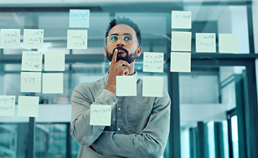 photo: man with crossed arms looking at notes (iStockphoto)