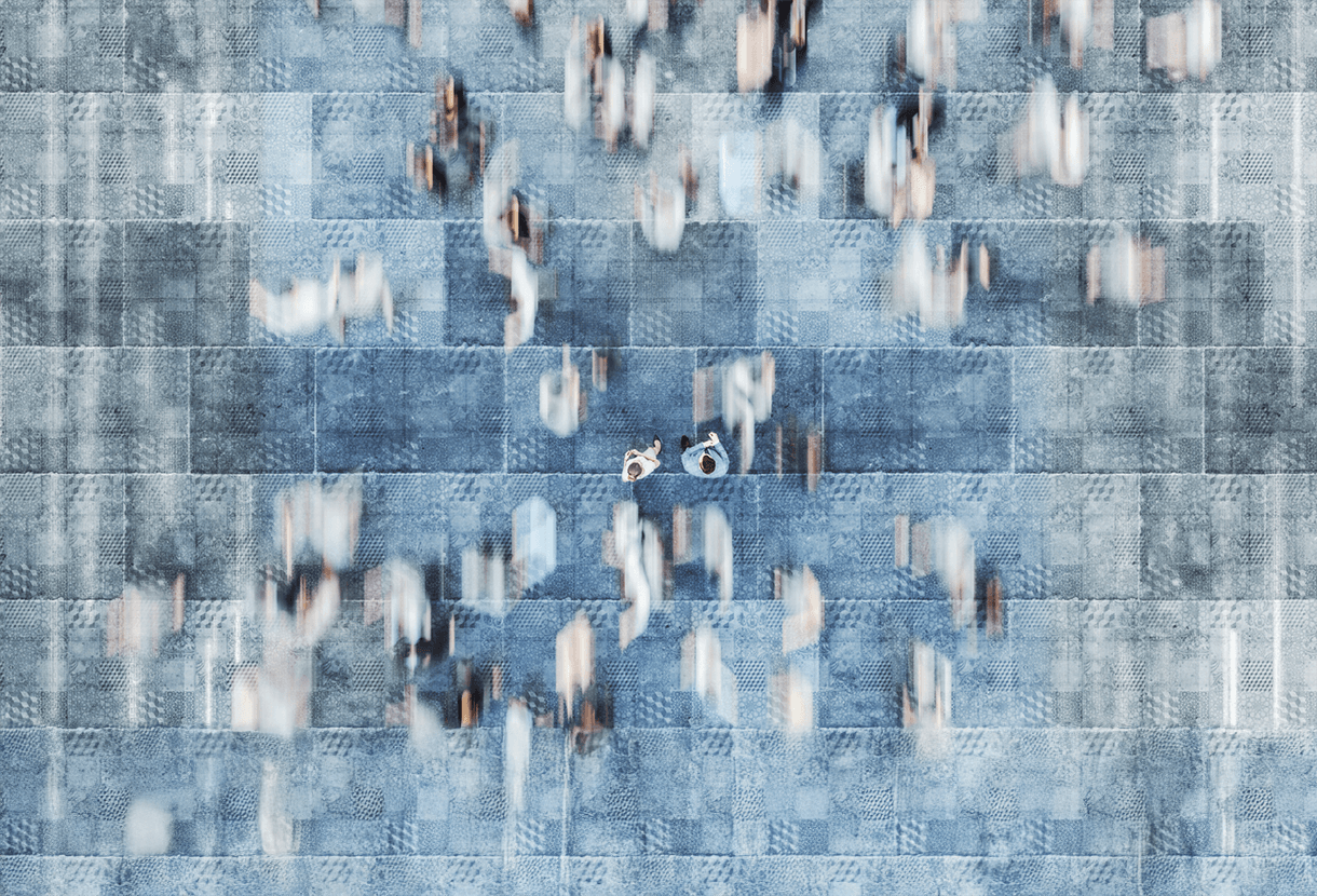 photo: bird's-eye view of blurred crowd. In the middle are two figures who are not moving. (iStockphoto)